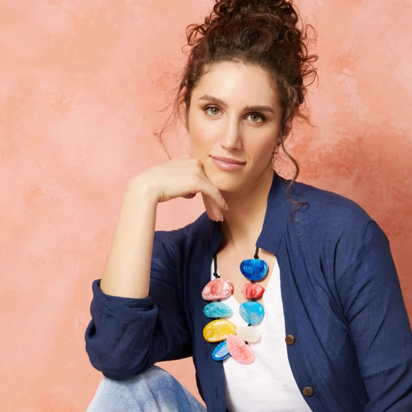 Woman wearing colorful necklace and cardigan.